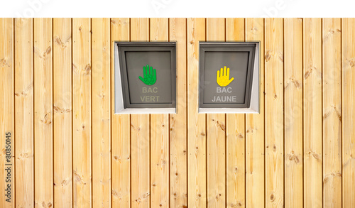 poubelles de tri sélectif derrière palissade bois