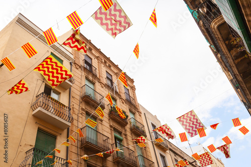 Flags of Tarragona city and Catalonia hanging over street