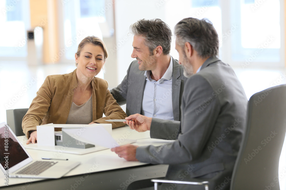 Mature couple meeting architect for construction project Mature couple meeting architect for construction project