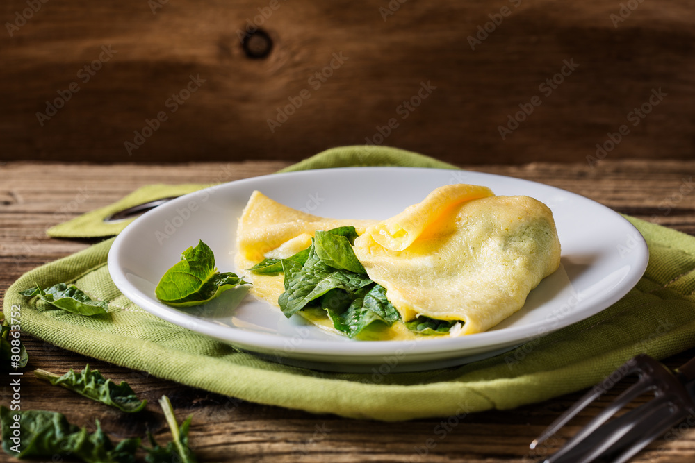 Homemade healthy spinach omelette on rural table