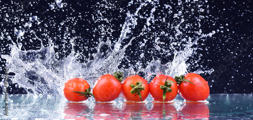 Macro drops on the red cherry tomatoes and make splash
