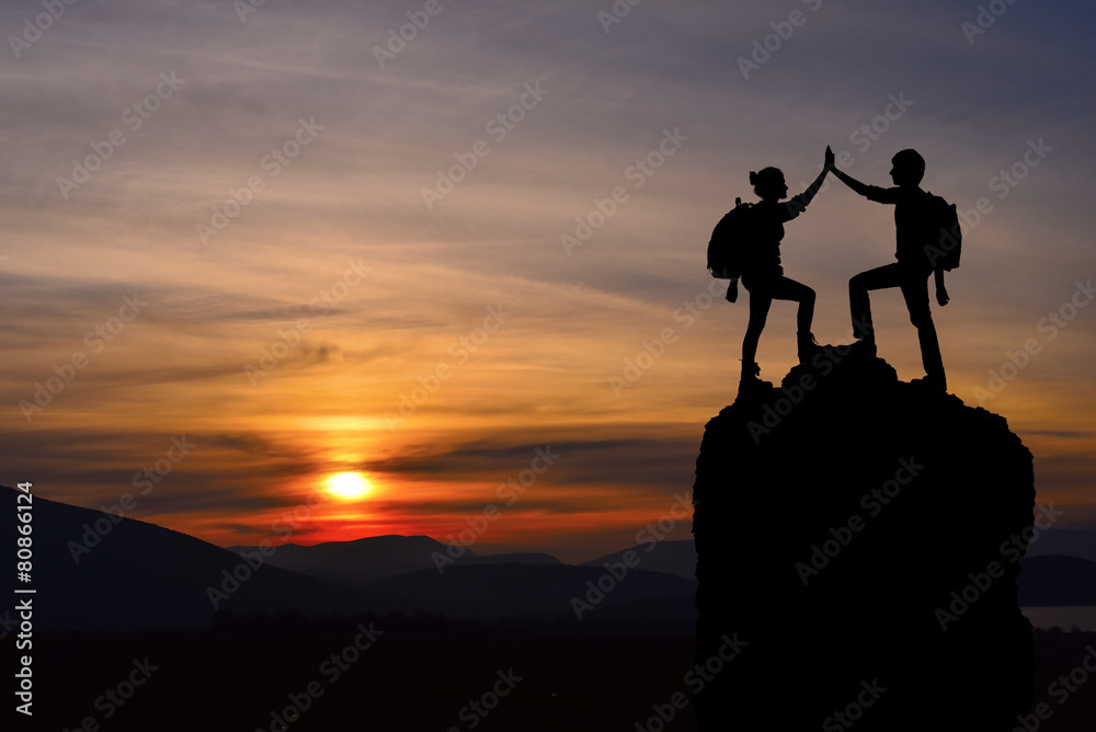 Silhouette of two people man girl success on the mountain