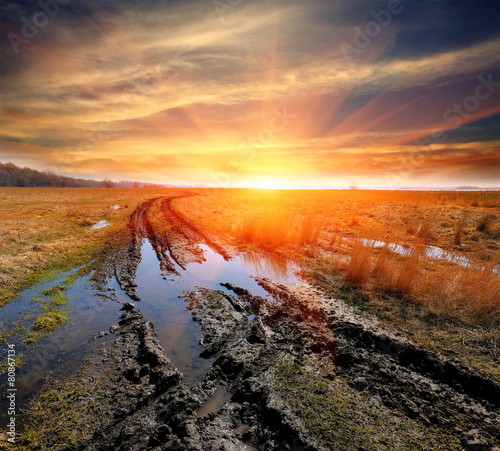 dirt road in steppe on sunset background
