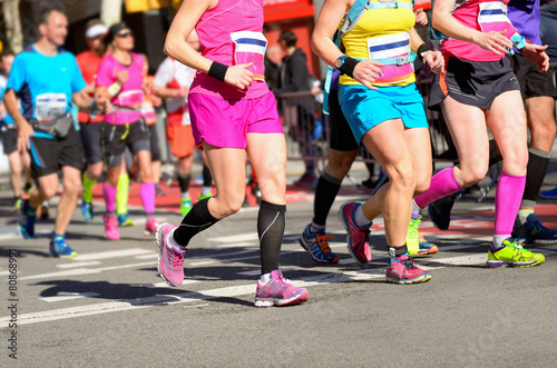 Marathon running race, women runners feet on road, sport concept