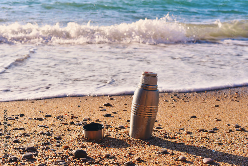 Heat protection-thermos coffee tea cup on the beach Heat protection-thermos coffee tea cup on the beach