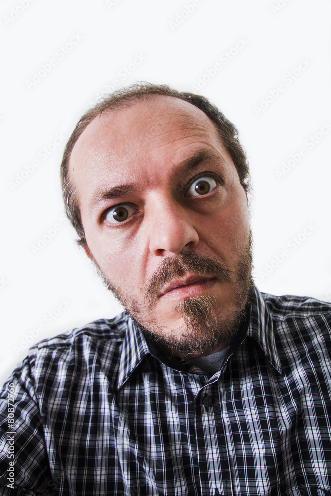 Surprised man in plaid shirt, eyes wide open Surprised man in plaid shirt, eyes wide open