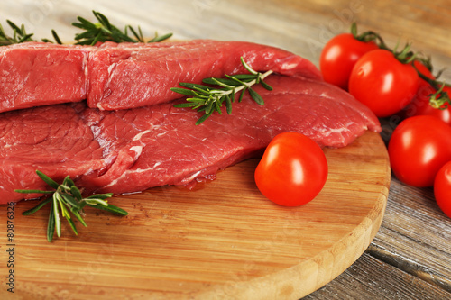 Raw beef steak with rosemary and cherry tomatoes