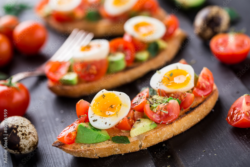 Bruschetta with tomato, avocado and quail egg Bruschetta with tomato, avocado and quail egg