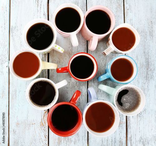 Many cups of coffee on wooden background