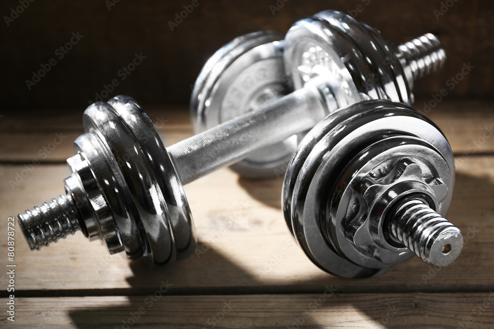 Naklejka premium Big dumbbells on wooden background