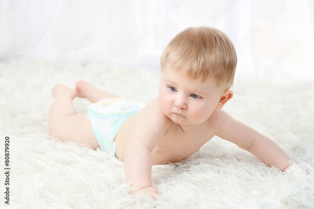 Cute baby boy on carpet, on light background Cute baby boy on carpet, on light background