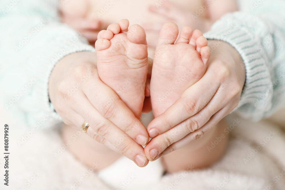 Newborn baby feet on female hands, close-up Newborn baby feet on female hands, close-up