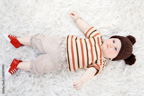 Cute baby boy lying on carp...
