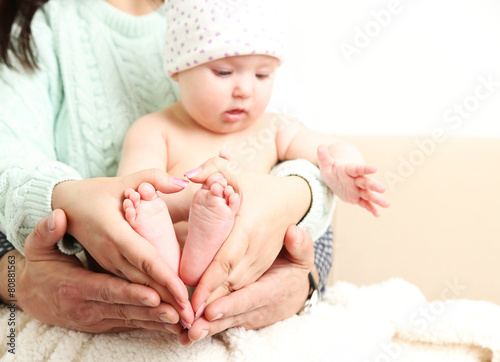 Newborn baby on father and mother hands, close-up