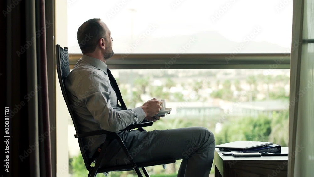 Young businessman relaxing and drinking coffee sitting on chair Young businessman relaxing and drinking coffee sitting on chair