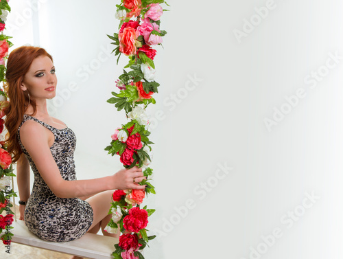 Beautiful woman in the floral swing
