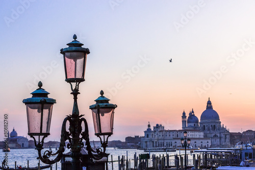 Italy Venice island city at sunset view over gondola poles to Sa photo