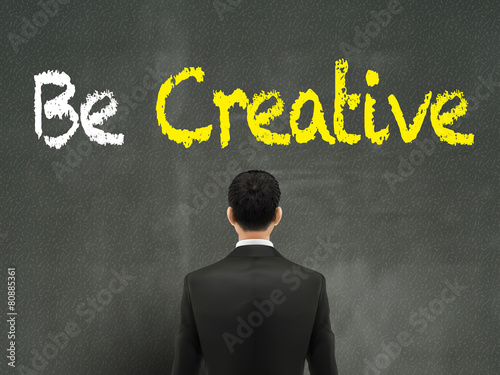 businessman looking at be creative words