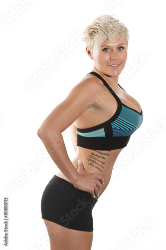 Blonde female fitness model posing in studio.