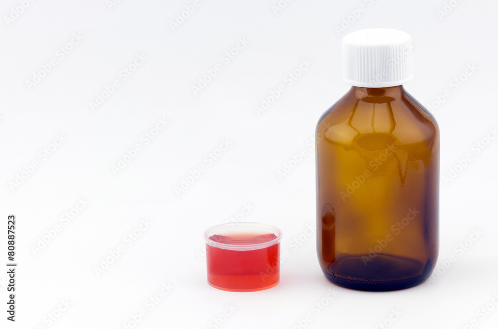 Cough syrup glass bottle with dosage cup filled up red syrup Cough syrup glass bottle with dosage cup filled up red syrup