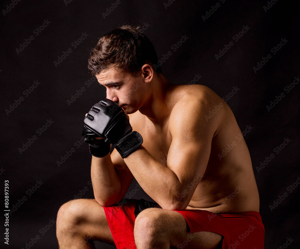 Portrait of boxer posing studio in gloves.