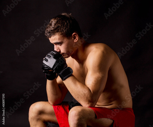 Portrait of boxer posing studio in gloves. © indigolotos