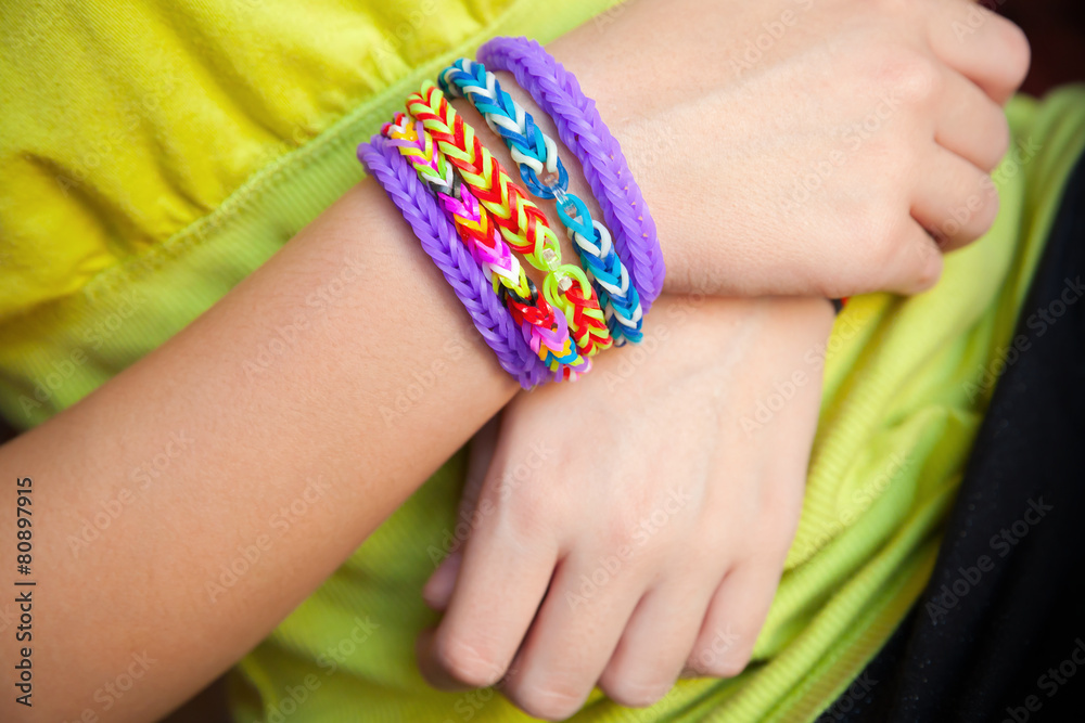 Fototapeta premium Child hands with Colorful rubber rainbow loom band bracelet