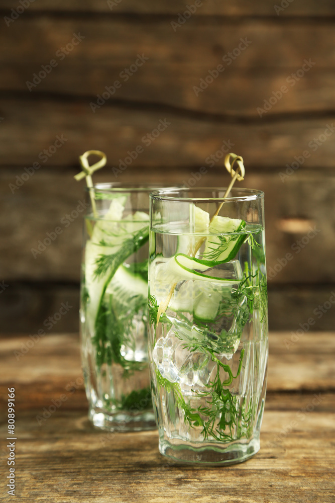 Glasses with fresh organic cucumber water on wooden table Glasses with fresh organic cucumber water on wooden table