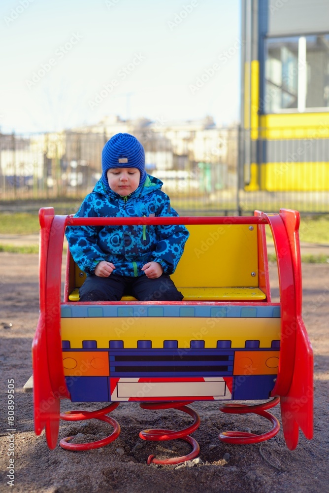 The little boy at a playground plays on the children's machine
