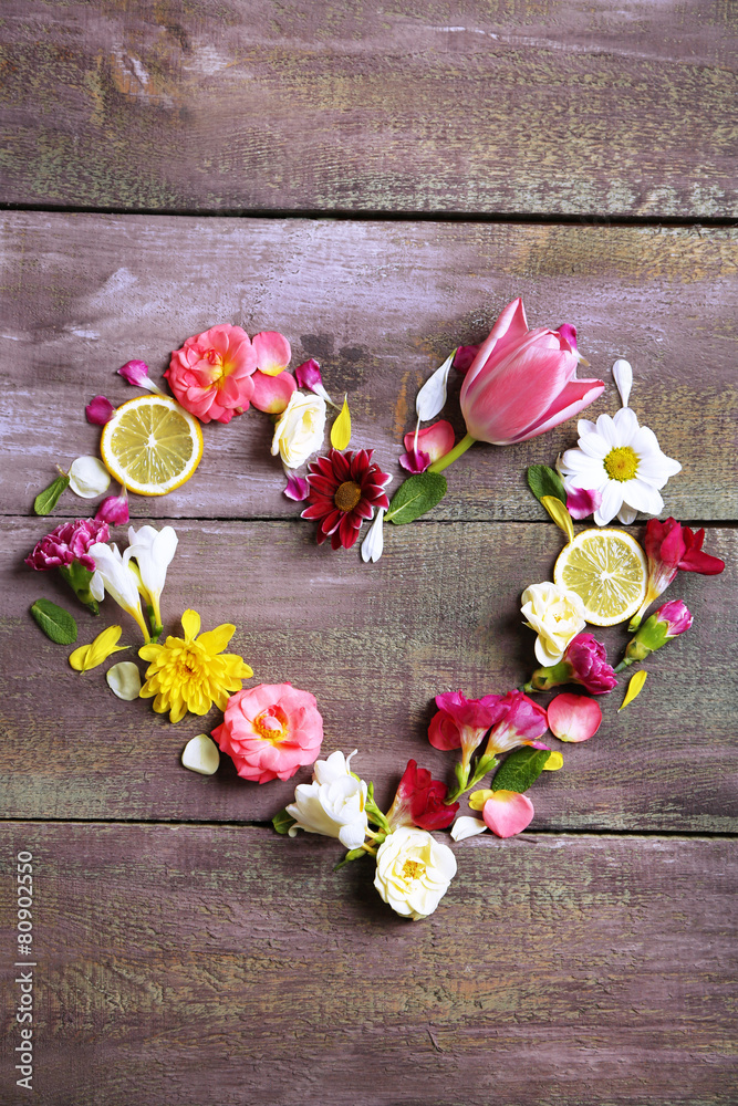 Heart of beautiful flowers, on wooden table Heart of beautiful flowers, on wooden table