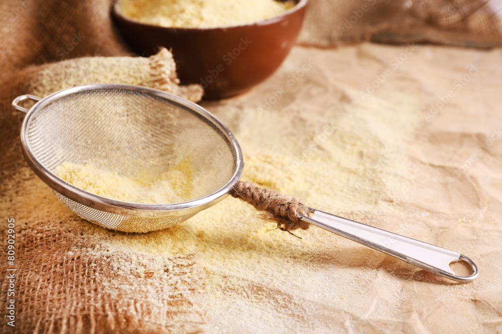 Flour in bowl with sieve on burlap cloth background Flour in bowl with sieve on burlap cloth background