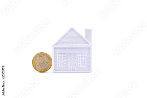 euro coin next to the house on a white background