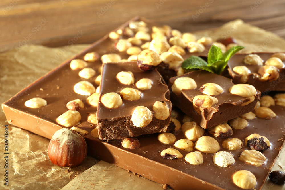 Chocolate with nuts on parchment, closeup Chocolate with nuts on parchment, closeup