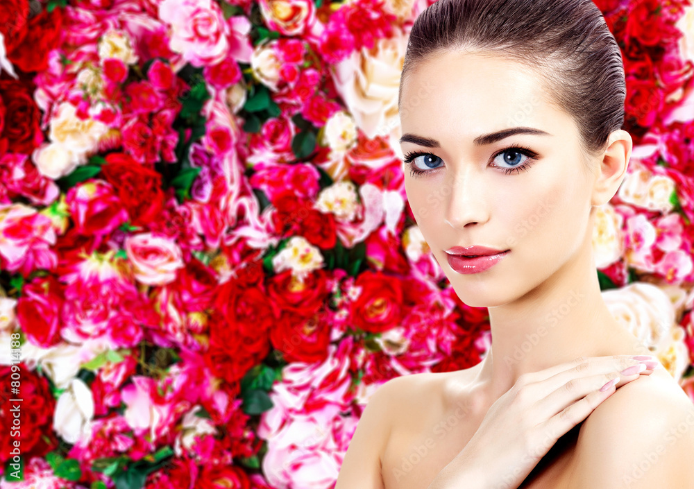 Beautiful woman on a floral background with red and white roses Beautiful woman on a floral background with red and white roses