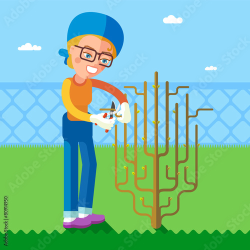 Garden. The woman cuts off branches using pruning shears.