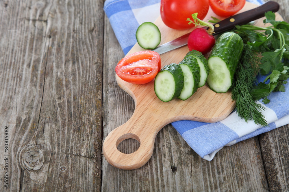 Cucumbers and tomatoes on a cutting board