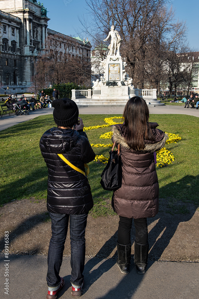 Obraz premium Besucher vor dem Mozart Denkmal in Wien