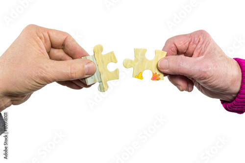 Two hands uniting fitting puzzle pieces