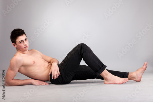 Healthy muscular young man on grey background