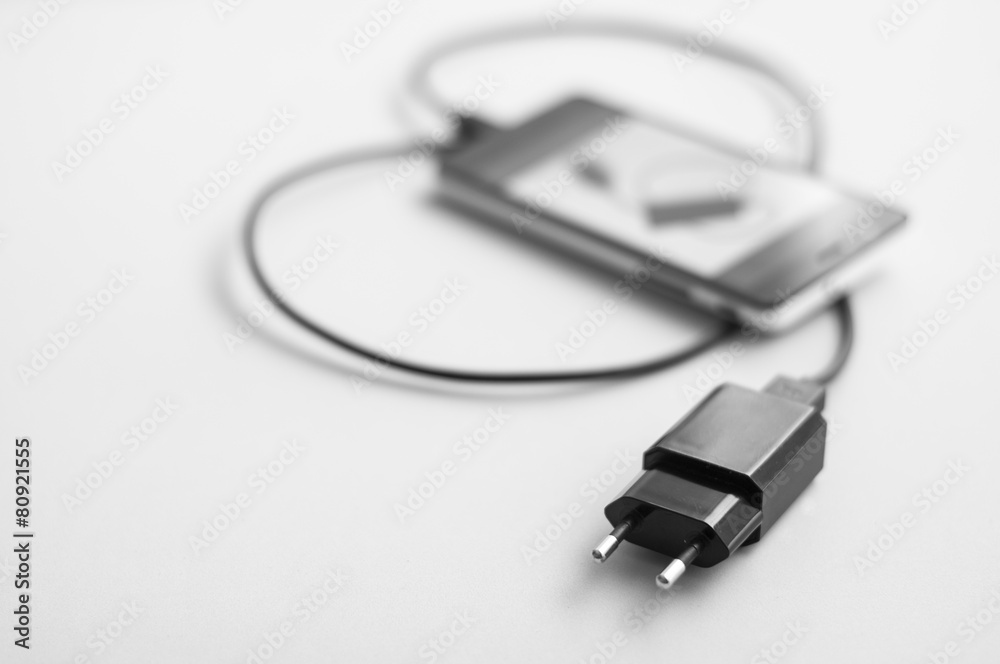 Fototapeta premium Móvil y cargador de móvil en blanco y negro