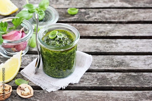 Basil pesto on a rustic wooden table.Selective focus.