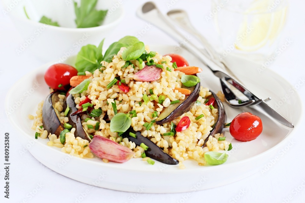 Bulgur salad with vegetables and herbs on a white background. Bulgur salad with vegetables and herbs on a white background.