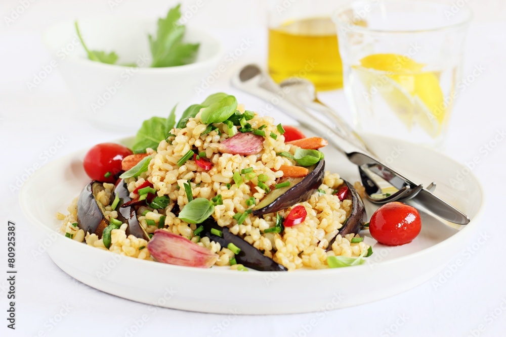 Bulgur salad with vegetables and herbs on a white background. Bulgur salad with vegetables and herbs on a white background.
