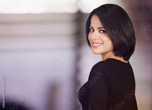 Beautiful latin woman looking back and smiling