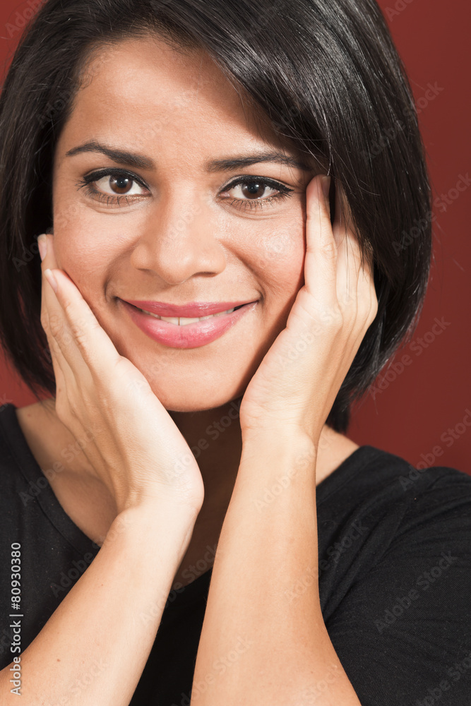 Beautiful woman touching her face isolated over a red background Beautiful woman touching her face isolated over a red background