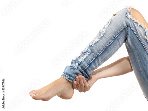 A young woman massaging her painful ankle