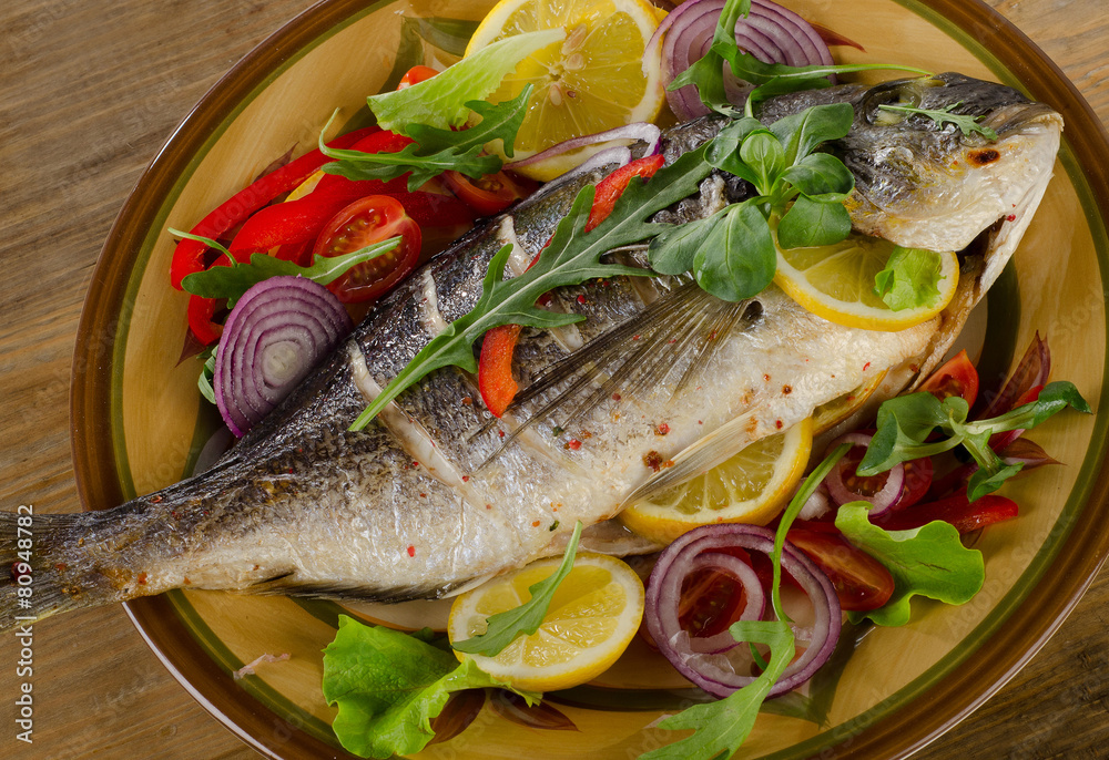 Fried dorado fish on plate with fresh salad and lemon. Fried dorado fish on plate with fresh salad and lemon.