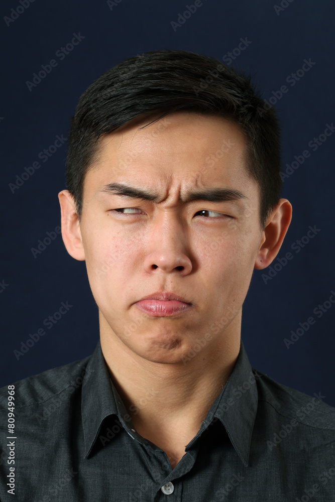 Obraz premium Young Asian man making face and looking sideways