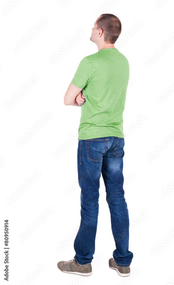 Back view of young man in t-shirt and jeans looking. Back view of young man in t-shirt and jeans looking.