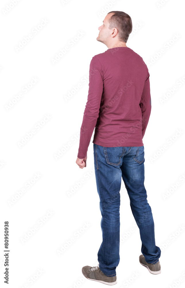 Back view of young man in t-shirt and jeans looking. Back view of young man in t-shirt and jeans looking.